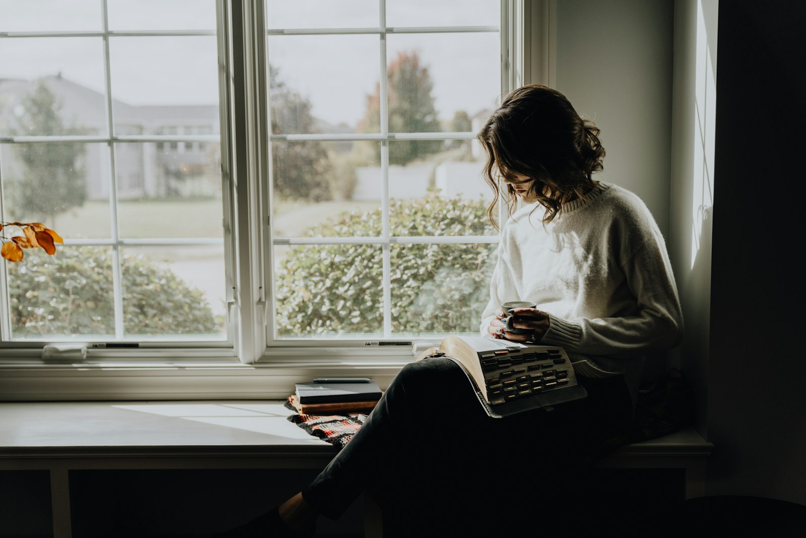 Vrouw leest een brief bij het raam